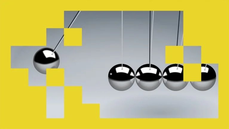 A close up view of a single ball swinging to collide with four others in a silver metallic Newton039s cradle